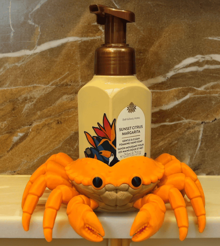 Bright orange crab toy with sunset citrus hand soap bottle behind it. Acadiana3DPrints